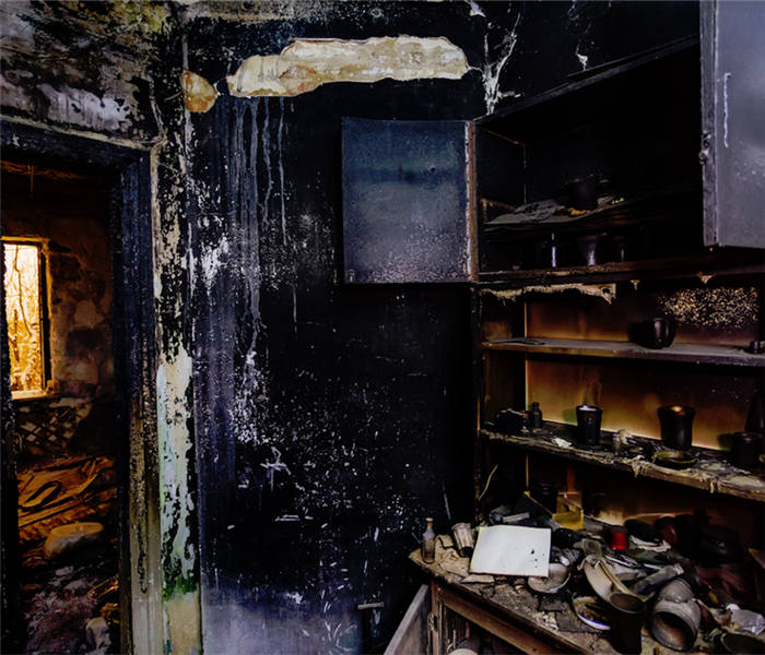 a fire damaged room with soot covering everything