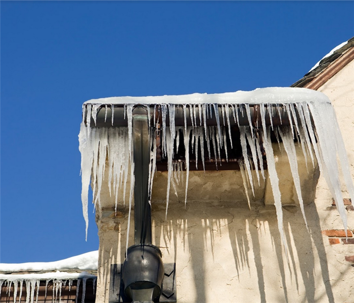 icicles hanging off of the gutters and pipes of a house