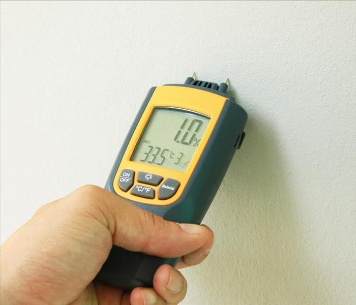 moisture meter pinned to a wall